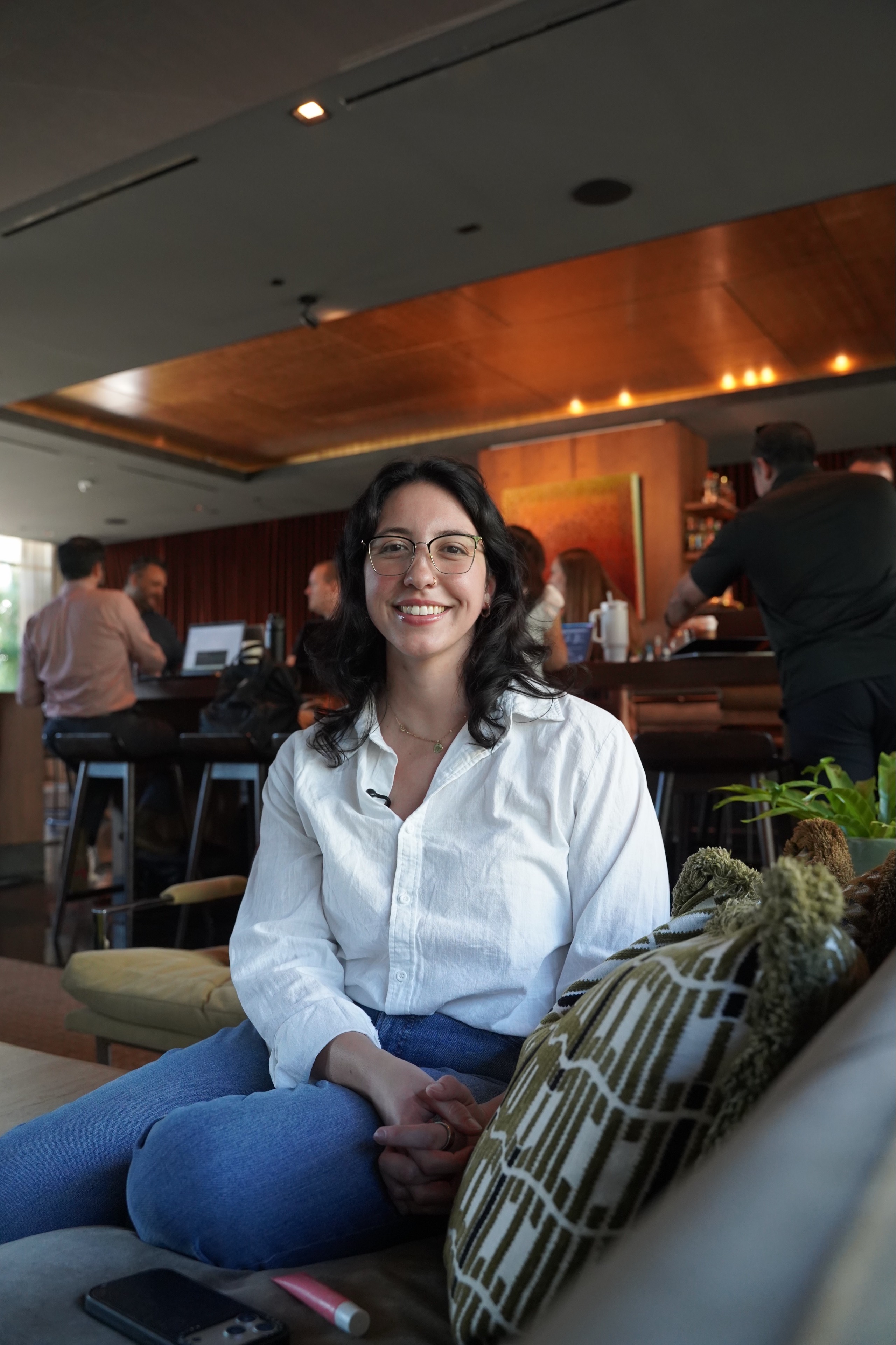 Alyssa smiling during a seated conversation on a sofa.