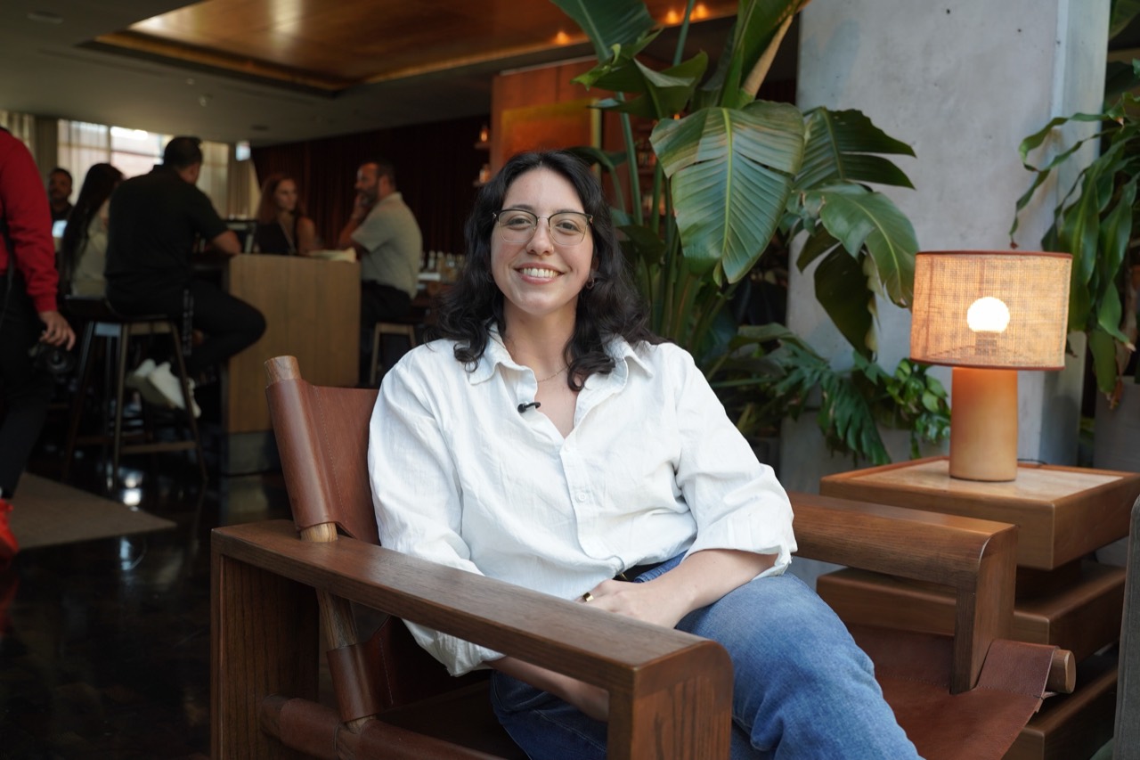 Alyssa smiling, seated in a wooden armchair.